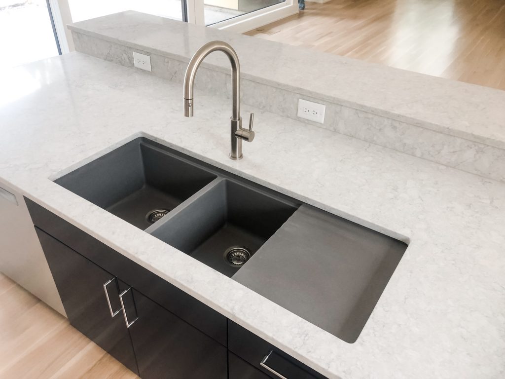 California Faucets Satin Nickel Corsano pulldown faucet on a Metallic Gray Silgranite sink.
